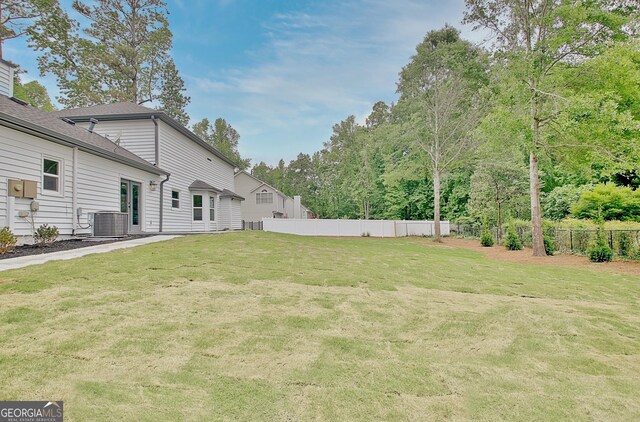 view of yard with fence and central AC unit