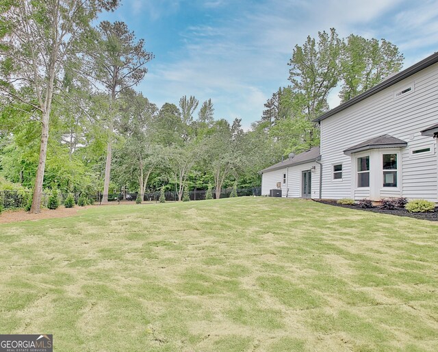 view of yard with fence and central AC unit