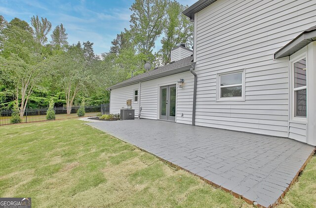 exterior space featuring french doors, a lawn, central air condition unit, fence, and a patio