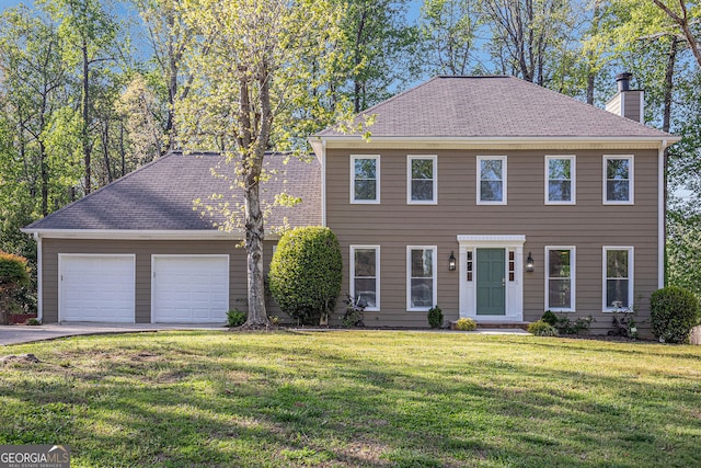 colonial house with a garage, a chimney, a front yard, and aphalt driveway