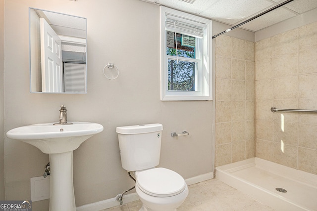 full bath featuring baseboards, tile patterned flooring, a shower stall, and toilet