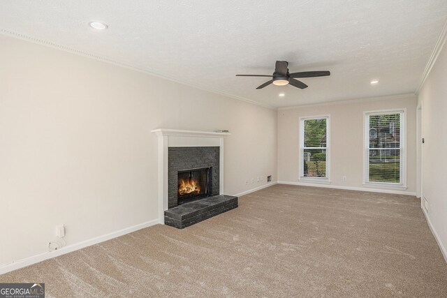 unfurnished living room with crown molding, a fireplace, ceiling fan, recessed lighting, and carpet