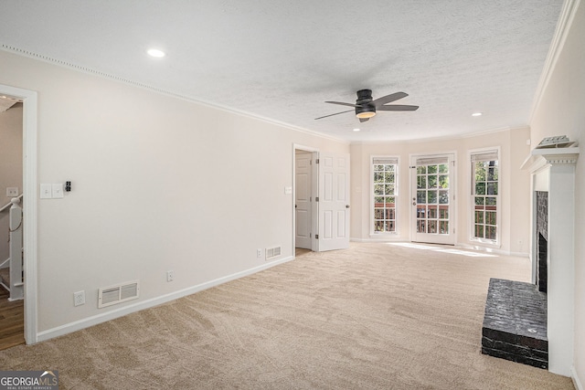 unfurnished living room with carpet floors, ceiling fan, visible vents, and ornamental molding