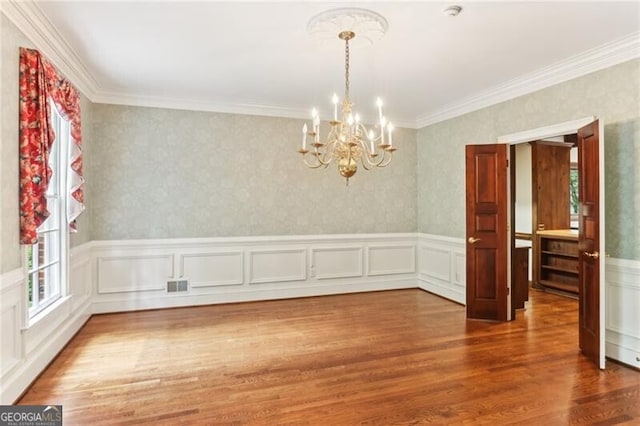 769 Hampton Pl SW, Marietta, GA 30064 - unfurnished dining area featuring a notable chandelier, wainscoting, wood finished floors, visible vents, and ornamental molding