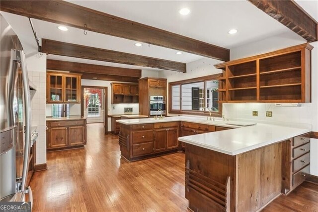 769 Hampton Pl SW, Marietta, GA 30064 - kitchen with brown cabinetry, dark wood-style flooring, a peninsula, and stainless steel fridge with ice dispenser