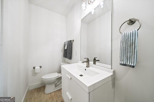 1676 Carroll Dr NW, Atlanta, GA 30318 - bathroom with vanity, baseboards, toilet, and wood finished floors