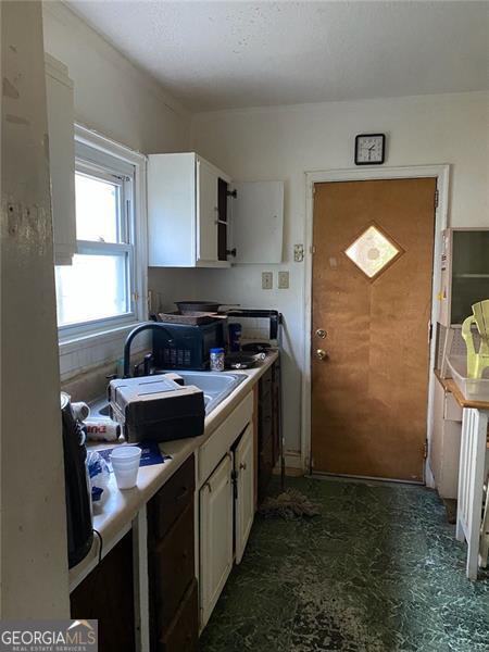 2689 Knox St, Atlanta, GA 30317 - kitchen with white cabinets, dark floors, and light countertops
