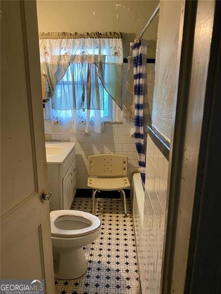 2689 Knox St, Atlanta, GA 30317 - bathroom with tile patterned floors, vanity, toilet, and tile walls