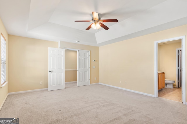 3845 New Salem Ct, Cumming, GA 30040 - unfurnished bedroom with a raised ceiling, light colored carpet, connected bathroom, a closet, and a ceiling fan