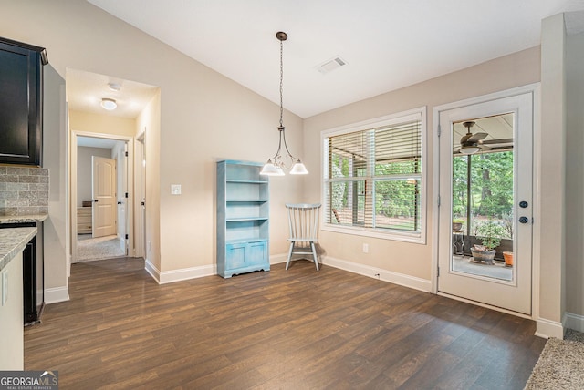 unfurnished dining area featuring visible vents, an inviting chandelier, lofted ceiling, baseboards, and dark wood-style floors