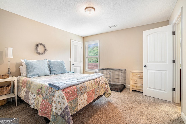 bedroom featuring carpet flooring, a textured ceiling, and visible vents