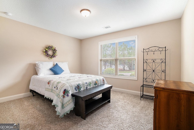 bedroom featuring baseboards, visible vents, and light carpet