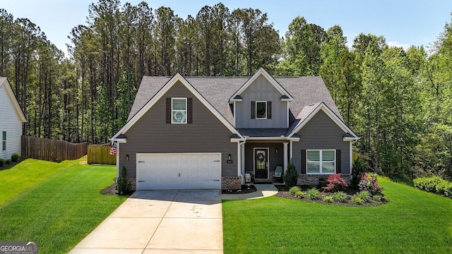 craftsman-style home with board and batten siding, driveway, a front yard, a garage, and fence