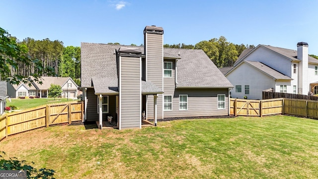 back of property with a fenced backyard, a chimney, and a lawn