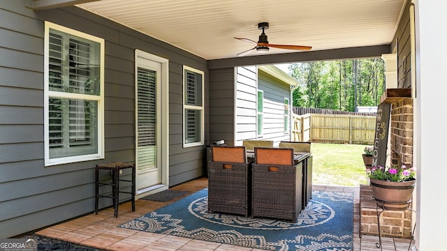 view of patio / terrace with ceiling fan, fence, and outdoor dining space