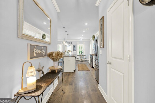 corridor with crown molding, a sink, dark wood finished floors, recessed lighting, and baseboards