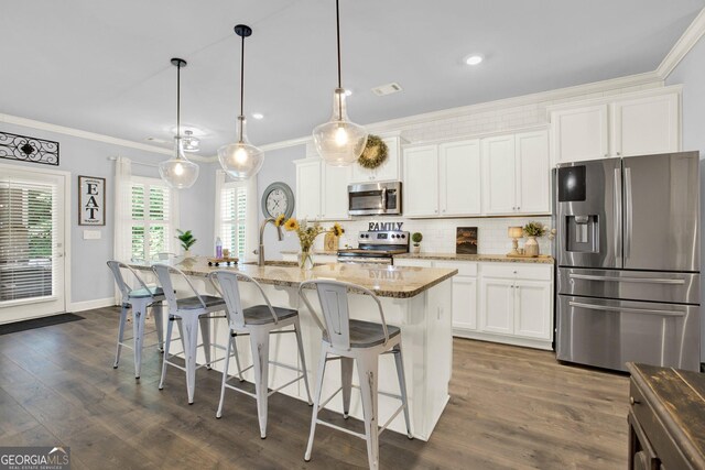 kitchen with decorative backsplash, crown molding, a sink, light stone counters, and stainless steel appliances