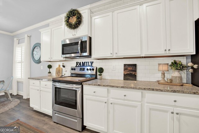kitchen with crown molding, white cabinets, dark wood finished floors, stainless steel appliances, and tasteful backsplash
