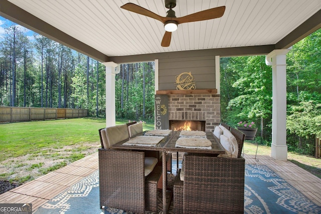 view of patio with a fenced backyard, a ceiling fan, and an outdoor brick fireplace