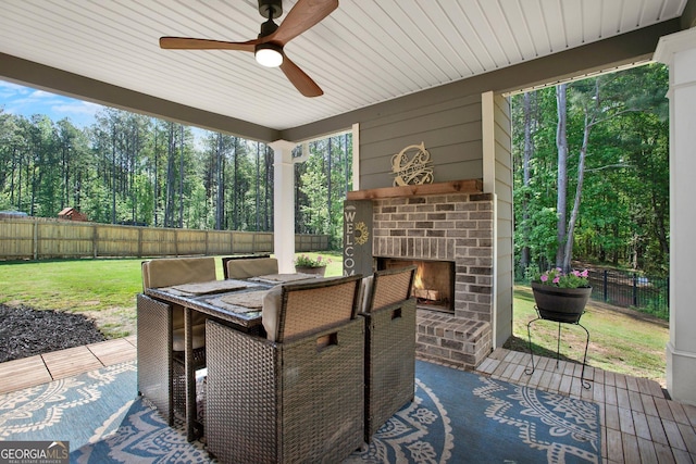 view of patio featuring ceiling fan, a fenced backyard, and an outdoor brick fireplace