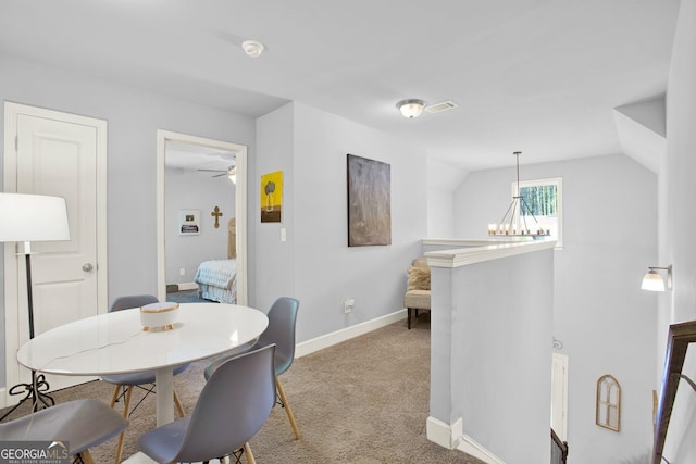 carpeted dining area featuring a ceiling fan, baseboards, visible vents, and vaulted ceiling