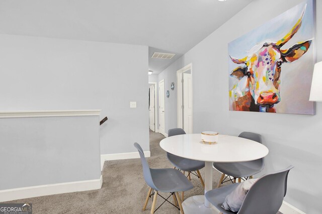 carpeted dining space featuring baseboards and visible vents