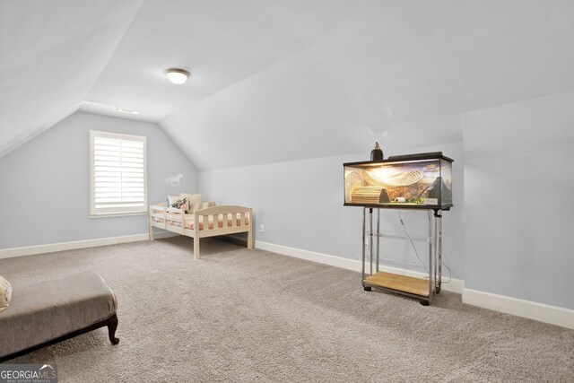 carpeted bedroom featuring baseboards and lofted ceiling