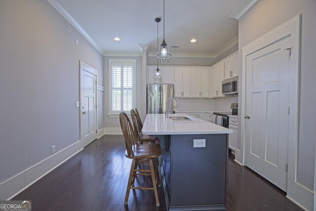 4143 N Swann St, Covington, GA 30014 - kitchen with crown molding, appliances with stainless steel finishes, a sink, dark wood-style floors, and white cabinetry