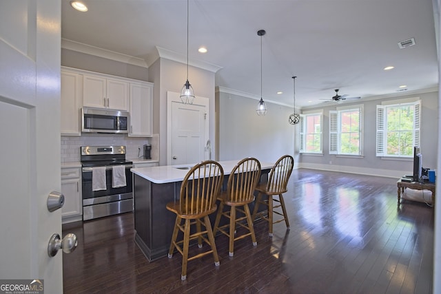 4143 N Swann St, Covington, GA 30014 - kitchen with crown molding, visible vents, baseboards, light countertops, and stainless steel appliances