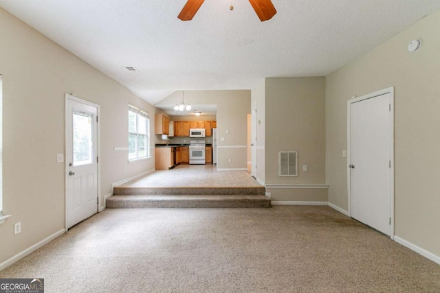 4870 Heather Mill Trce, Snellville, GA 30039 - unfurnished living room with baseboards, light carpet, visible vents, and ceiling fan with notable chandelier