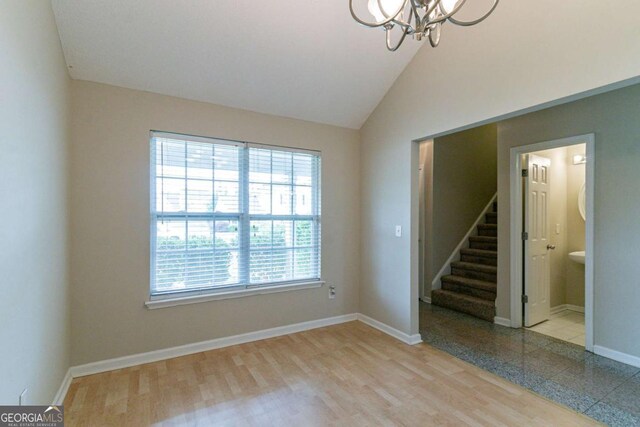 4870 Heather Mill Trce, Snellville, GA 30039 - empty room featuring lofted ceiling, baseboards, an inviting chandelier, stairs, and wood finished floors