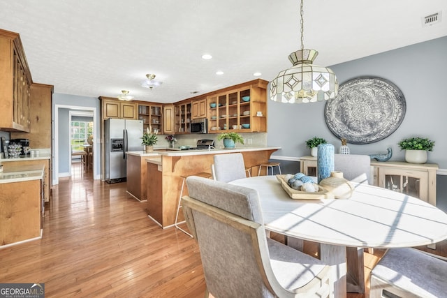 dining area with visible vents, recessed lighting, light wood finished floors, and baseboards