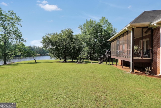 view of yard with a water view, a sunroom, and stairway