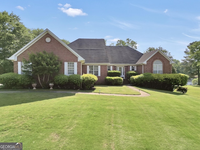single story home featuring brick siding and a front yard