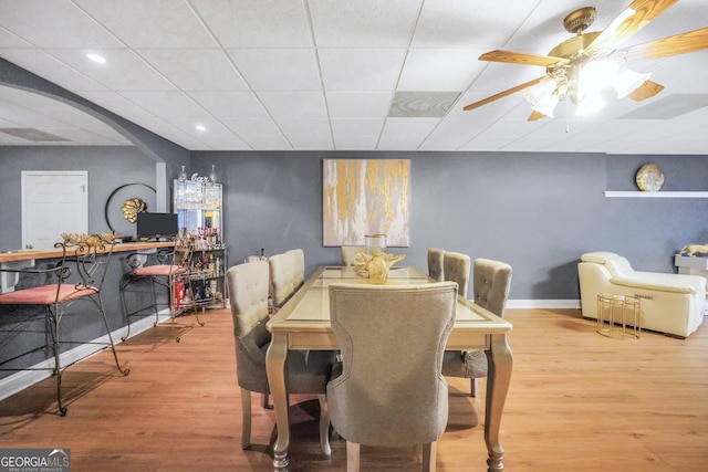 dining room with ceiling fan, a drop ceiling, recessed lighting, and wood finished floors