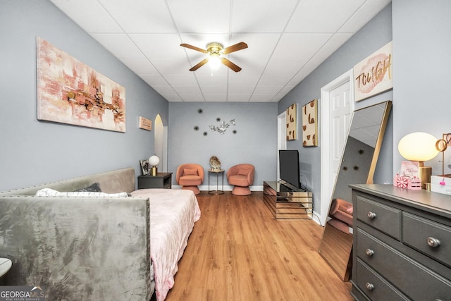 bedroom with light wood-style flooring and a paneled ceiling