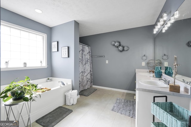 bathroom with a sink, a textured ceiling, double vanity, and a bath