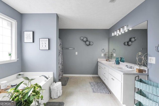 bathroom featuring double vanity, tile patterned flooring, a sink, and a garden tub