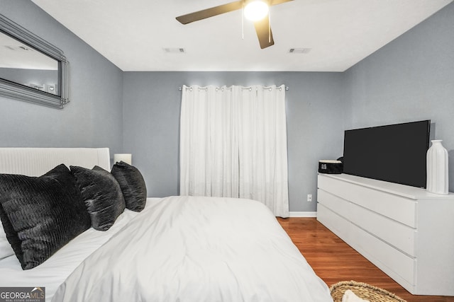 bedroom featuring visible vents, ceiling fan, and wood finished floors