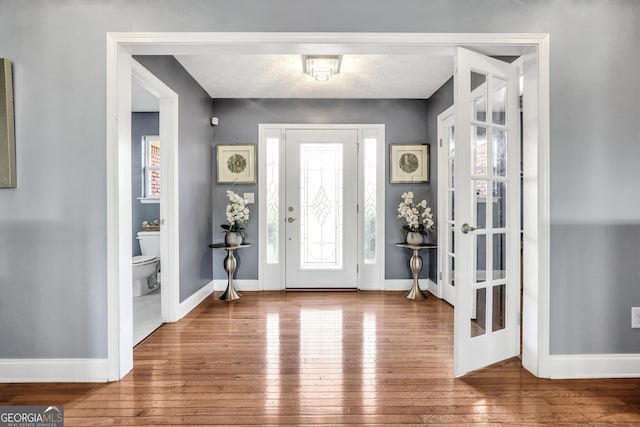 entrance foyer featuring baseboards and hardwood / wood-style flooring