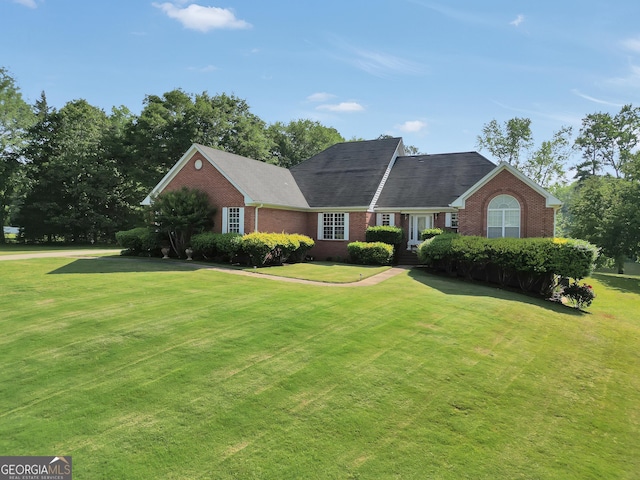 ranch-style house featuring brick siding and a front yard