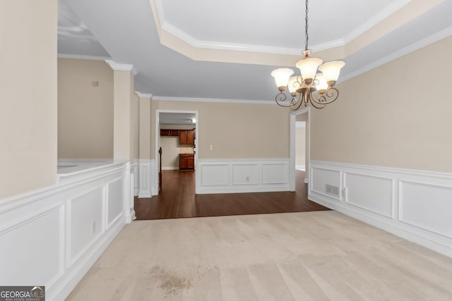 2055 Hickory Station Cir, Snellville, GA 30078 - unfurnished dining area with crown molding, wainscoting, a decorative wall, a tray ceiling, and a chandelier