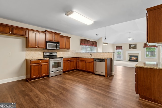 2055 Hickory Station Cir, Snellville, GA 30078 - kitchen featuring dark wood-type flooring, light stone counters, brown cabinets, and stainless steel appliances