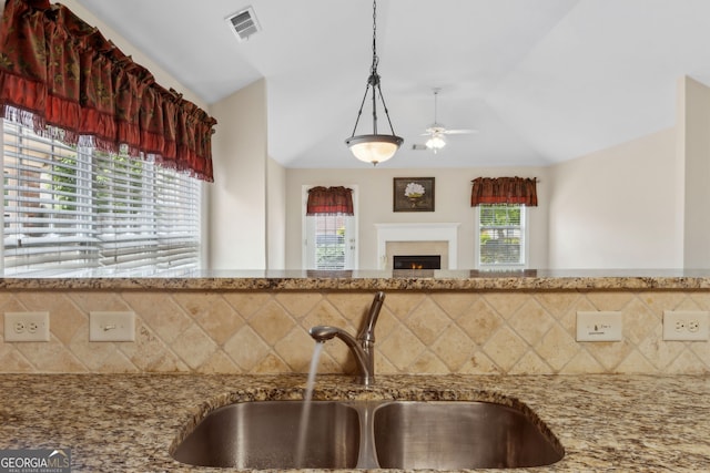 2055 Hickory Station Cir, Snellville, GA 30078 - kitchen with ceiling fan, tasteful backsplash, light stone counters, a sink, and vaulted ceiling