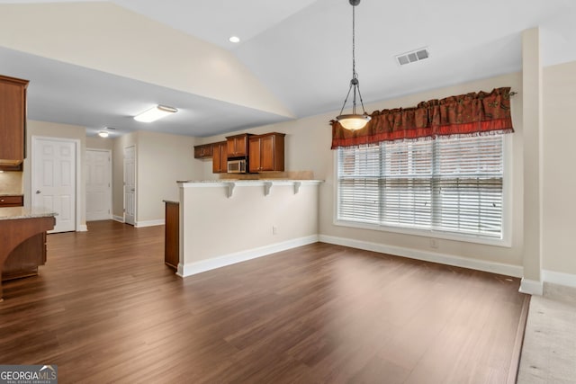 2055 Hickory Station Cir, Snellville, GA 30078 - kitchen featuring visible vents, a peninsula, stainless steel microwave, brown cabinets, and vaulted ceiling