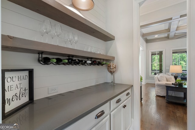 indoor dry bar with coffered ceiling, beam ceiling, dark wood-style flooring, and baseboards