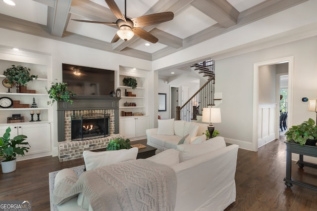 living room with coffered ceiling, a fireplace, ceiling fan, built in features, and dark wood-type flooring