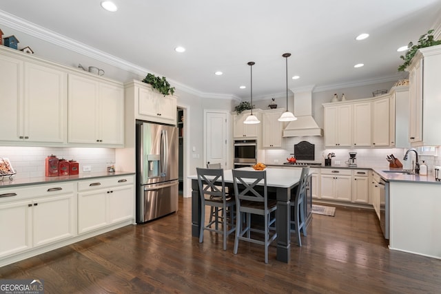 kitchen with appliances with stainless steel finishes, a sink, premium range hood, decorative backsplash, and recessed lighting