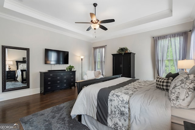 bedroom with a raised ceiling, ornamental molding, wood finished floors, and ceiling fan