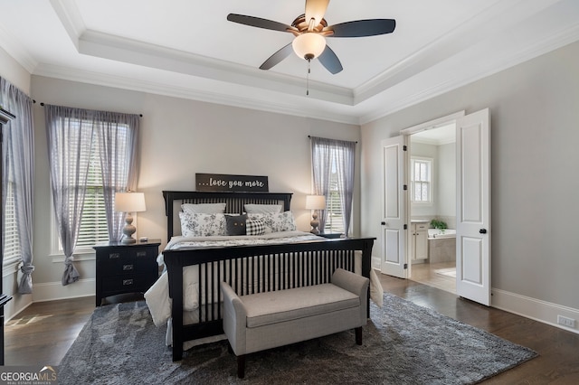 bedroom featuring a raised ceiling, ornamental molding, wood finished floors, and baseboards